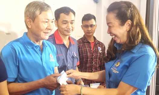 Bà Vũ Thế Vân - Chủ tịch Công đoàn các Khu chế xuất & công nghiệp TPHCM - tặng quà các công nhân bị tai nạn lao động. Ảnh: Nam Dương
