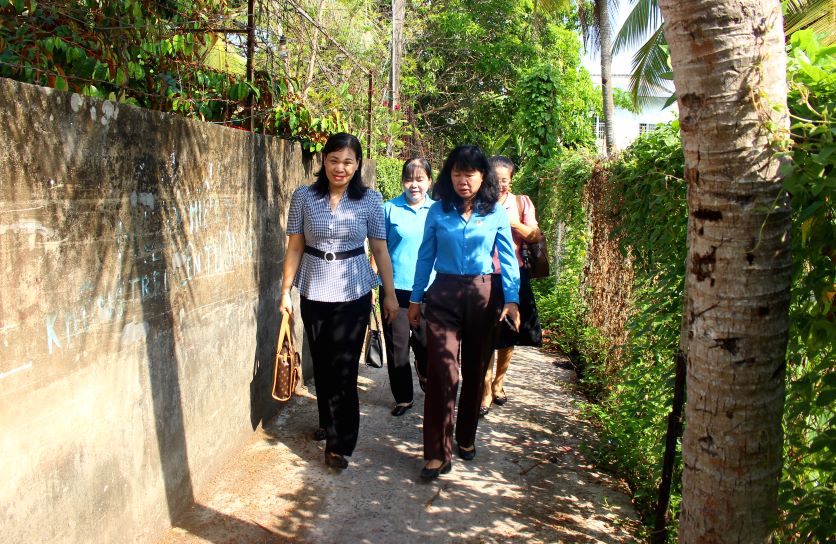 Chủ tịch LĐLĐ tỉnh Đồng Tháp Huỳnh Thị Tuyết Vui (bìa phải) cùng mọi người đi bộ vào hẻm nhỏ thăm hỏi đoàn viên Lê Văn Dũng (phường 2, TP Sa Đéc). Ảnh: Thanh Mai