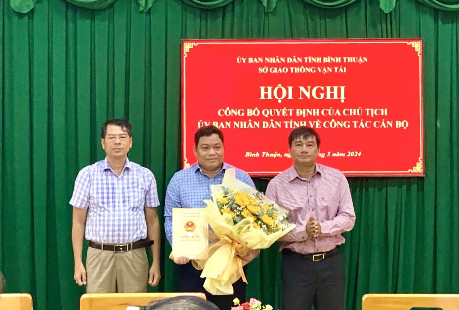 Giám đốc Sở Nội vụ và Giám đốc Sở GTVT trao Quyết định và trao hoa chúc mừng ông Nguyễn Thanh Long. Ảnh: Phạm Duy