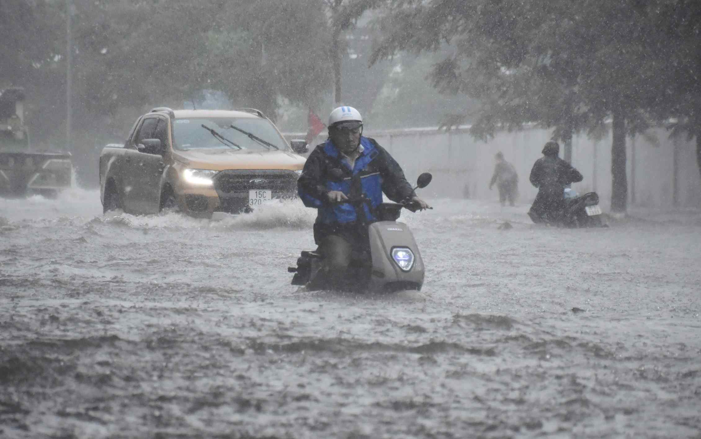 Nước ngập ngang xe khiến người dân vất vả khi di chuyển qua đường Hùng Vương. Nhiều chủ xe phải dắt bộ do bị xe chết máy. 