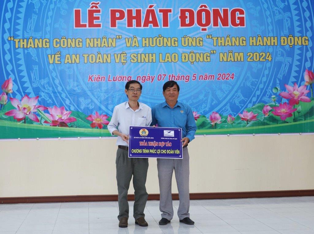 Chủ tịch LĐLĐ huyện Kiên Lương Lê Thanh Tòng (áo xanh) nhận bảng thỏa thuận hợp tác về dịch vụ khám, chữa bệnh với chính sách ưu đãi, giảm giá cho đoàn viên công đoàn. Ảnh: Mỹ Linh