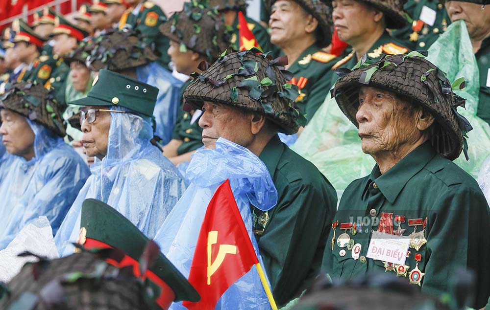 Nhiều Cựu chiến binh ngồi trên lễ đài vẫn phải mặc áo mưa mặc dù đã có mái che.