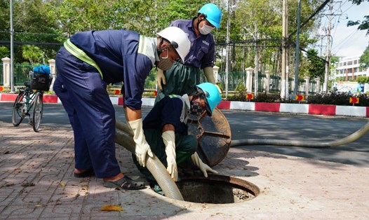 Các công nhân Công ty CP Công trình đô thị tỉnh Sóc Trăng được trang bị đầy đủ bảo hộ lao động trước khi tiến hành xuống cống thu gom nước thải. 
Ảnh: Phương Anh