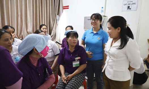 Chủ tịch LĐLĐ tỉnh Kiên Giang Trương Thanh Thúy (áo trắng) thăm hỏi đời sống, sức khỏe của nữ công nhân Công ty TNHH Hwaseung Rạch Giá. Ảnh: LĐLĐ Kiên Giang