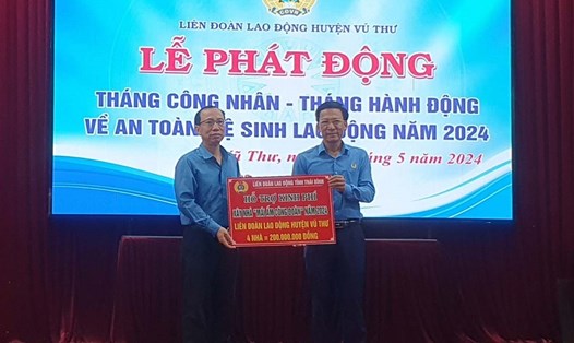 Lãnh đạo LĐLĐ tỉnh Thái Bình trao biển biểu trưng kinh phí hỗ trợ xây nhà cho đại diện LĐLĐ huyện Vũ Thư. Ảnh: Bá Mạnh