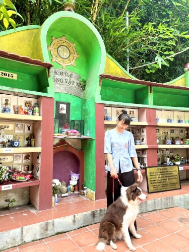 Chị Trà chụp cùng chú chó già nhất tại chùa. Ảnh: NVCC