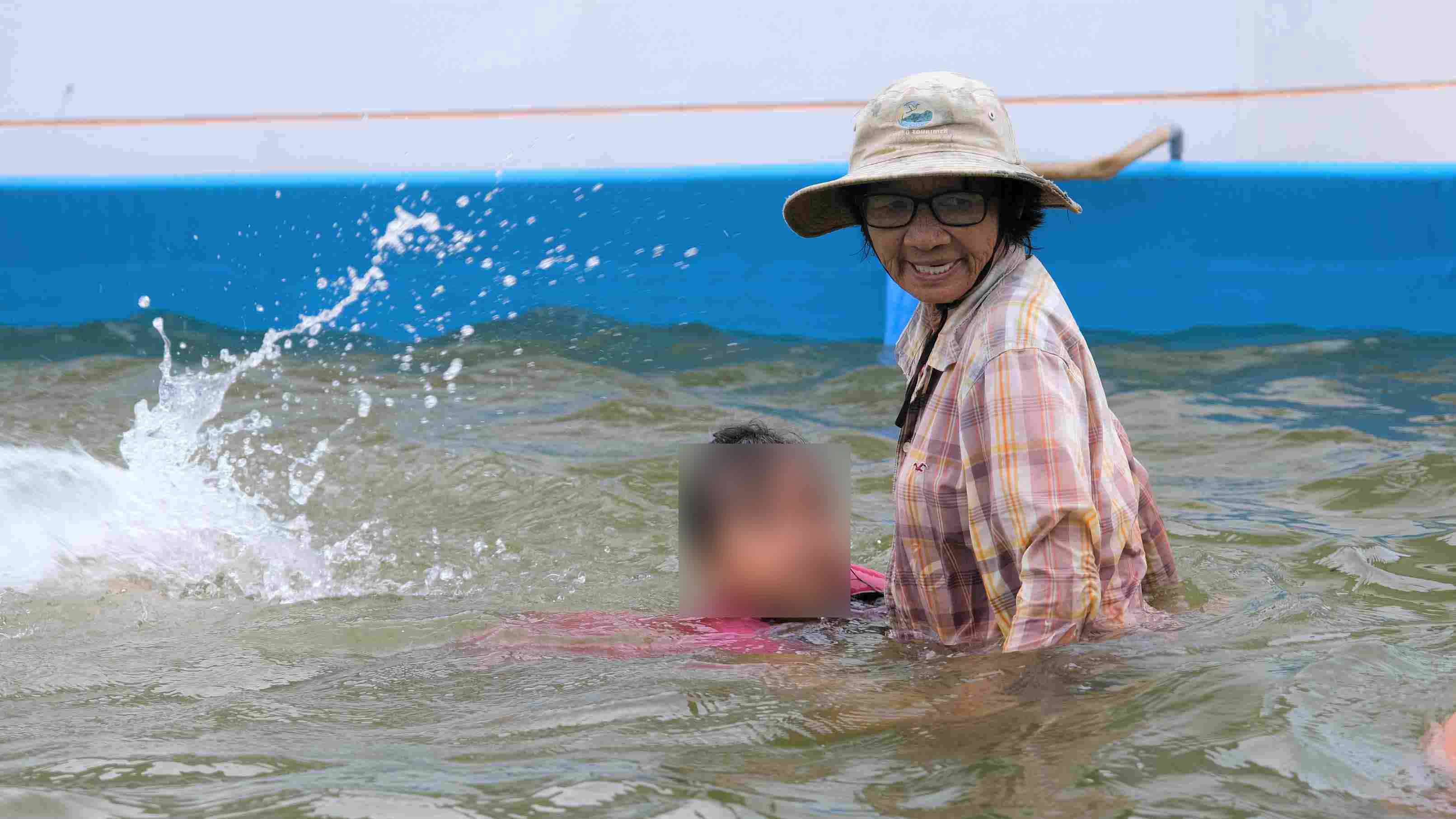 Bà Sáu Thia tận tình hướng dẫn tập bơi cho trẻ nhỏ. Ảnh: Phong Linh