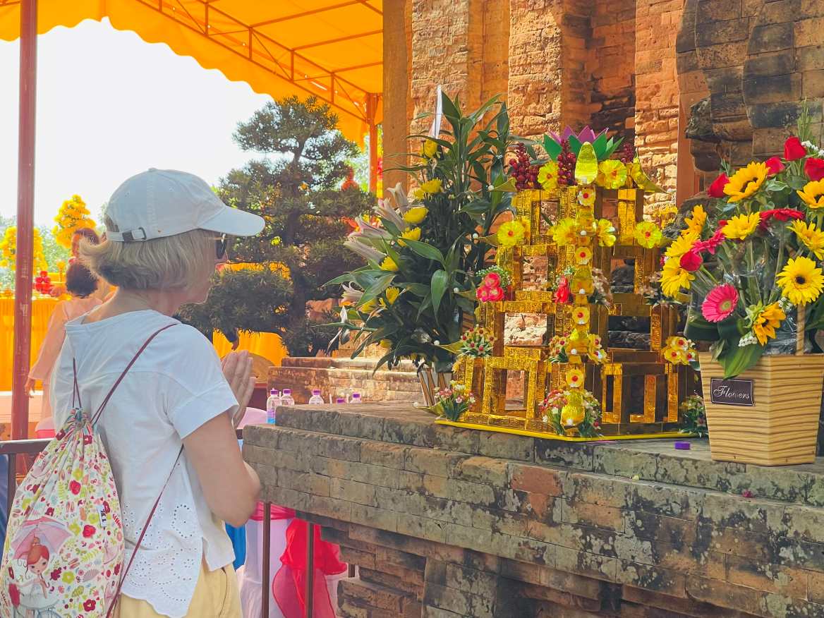 Du khách nước ngoài tìm hiểu văn hóa tín ngưỡng của người Việt tại Tháp Bà. Ảnh: P.Linh