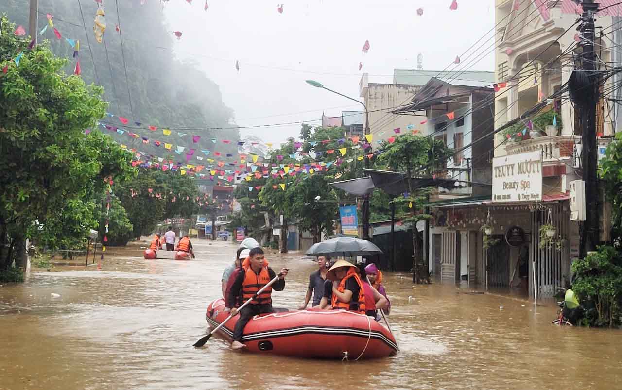 Nhiều tuyến đường của TP Hà Giang bị ngập sâu trong lũ, lực lượng chức năng phải dung thuyền cao su để di chuyển người dân. Ảnh: Công an Hà Giang.