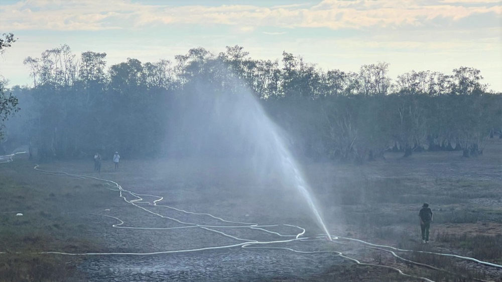 Lực lượng phun nước dập lửa ở Vườn Quốc gia Tràm Chim. Ảnh: Tùng Linh