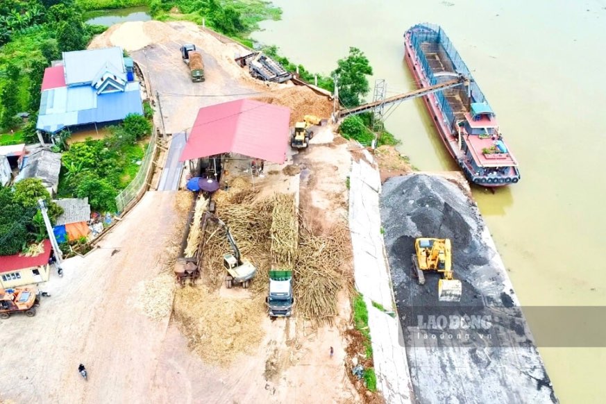 Khoáng sản tập kết sát bờ sông và xả thải trực tiếp ra môi trường. Ảnh: Việt Bắc.