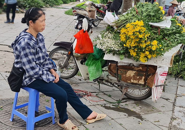 Có lương hưu nhưng bà Lài vẫn phải phụ bán hoa để thêm thu nhập. Ảnh: Mạnh Cường. 