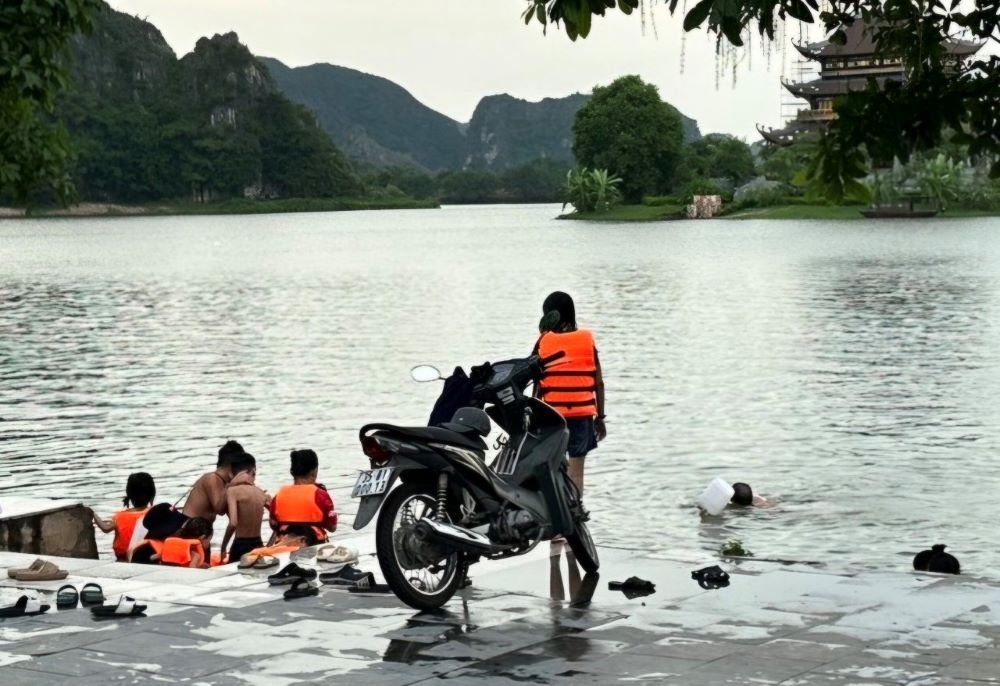 Bất chấp nguy hiểm, chiều đến nhiều người dân vẫn ra hồ Núi Lớ (thành phố Ninh Bình) để tắm giải nhiệt. Ảnh: Nguyễn Trường
