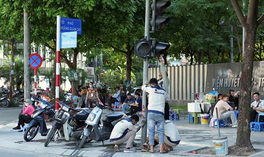 Công nhân lắp đặt các trụ đèn tín hiệu giao thông tại nút giao Phạm Văn Bạch - Hoàng Quán Chi, chiều 13.6. Ảnh: Sóng Hữu