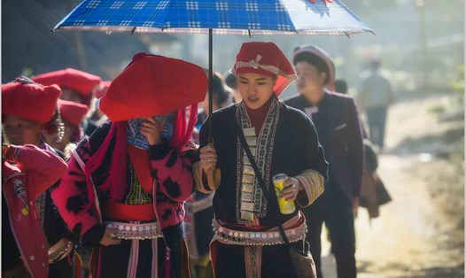 Cô dâu được phù dâu che ô đưa về nhà chồng. Ảnh: Nguyễn Tuấn Khoa