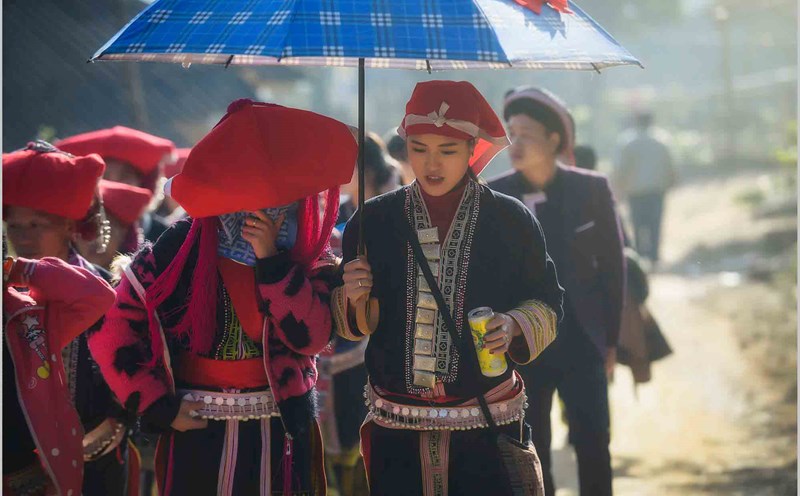 Cô dâu được phù dâu che ô đưa về nhà chồng. Ảnh: Nguyễn Tuấn Khoa