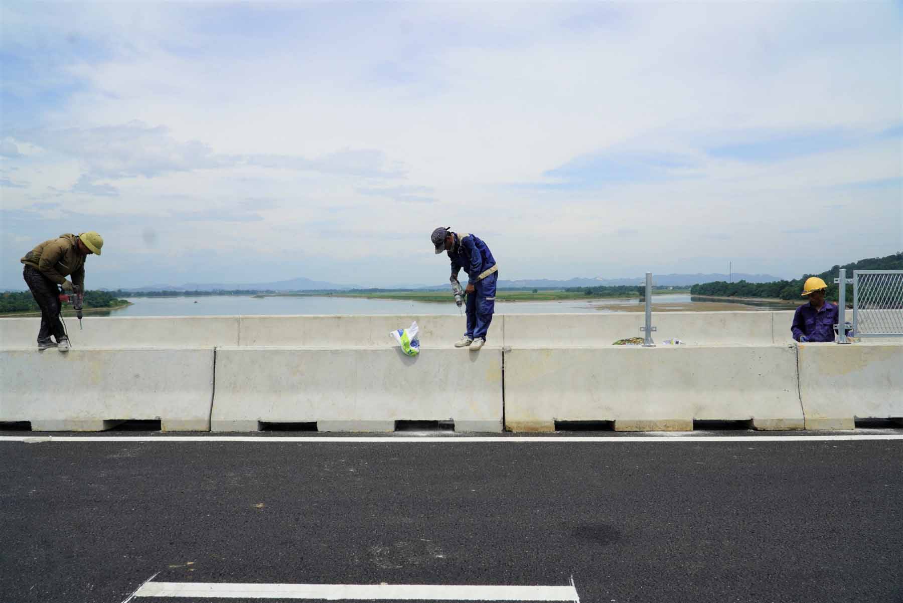 Công nhân thi công trên hạng mục dựng dải phân cách cứng trên cầu. Ảnh: Trần Tuấn.