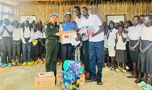Trung tá Bùi Phương Lân thay mặt tổ công tác Bộ Công an tại phái bộ UNMISS trao quà cho các em học sinh tại Trường Tiểu học Thống nhất, Nam Sudan. Ảnh: Bộ Công an