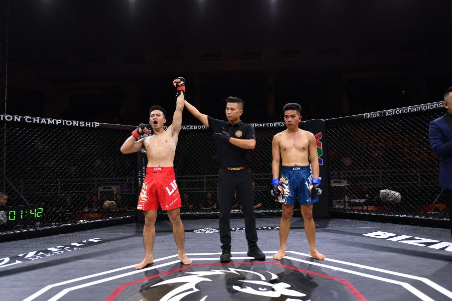 Ở hạng 56kg nam, Trần Văn Thanh Trinh (đỏ) có chiến thắng bằng knockout kỹ thuật trước Phan Ngọc Tuyết Dũng (xanh). Tại thời điểm 1 phút 18 giây hiệp 2, Tuyết Dũng đã có dấu hiệu choáng sau loạt đòn tay và gối của Thanh Trinh, qua đó buộc trọng tài phải cho dừng trận đấu. Ảnh: MMA