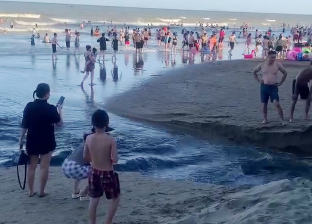 Thời điểm khách du lịch ghi lại cảnh nước thải đen xì chảy ra bãi biển Sầm Sơn sau đó đăng tải lên mạng xã hội, thu hút sự quan tâm của nhiều người. Ảnh: Cắt từ Clip