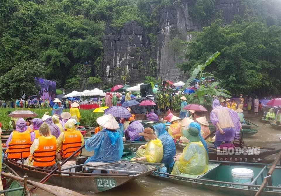 Du khách đội mưa đến tham quan tại Khu du lịch Tam Cốc - Bích Động. Ảnh: Nguyễn Trường