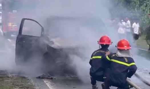 Lực lượng chữa cháy khống chế lửa phát ra từ chiếc xe ôtô 7 chỗ vừa đổ đèo Khánh Lê. Ảnh: P.Linh