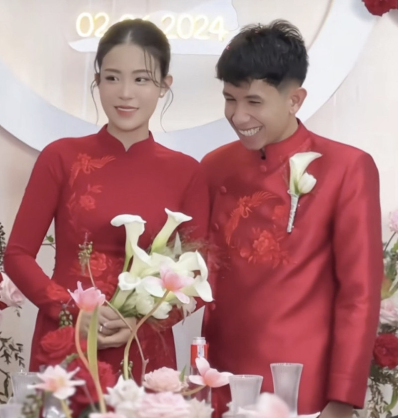 Hồng Duy và Kiều Oanh chọn trang phục áo dài đỏ trong lễ rước dâu về nhà trai. Ảnh: Cắt từ clip