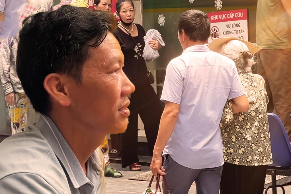 Người nhà bệnh nhân dùng khăn ướt đội đầu để chống chọi với nắng nóng