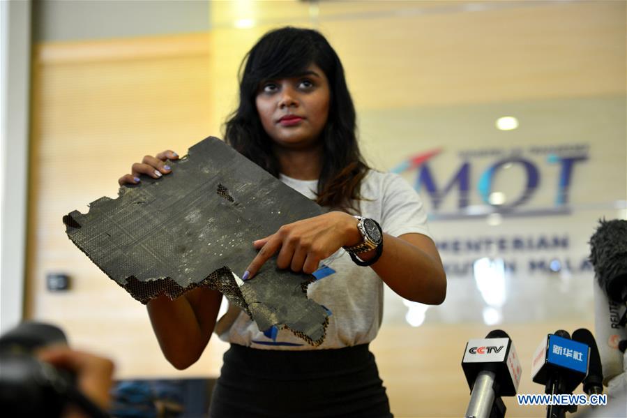 Thân nhân của hành khách MH370 cầm mảnh vỡ nghi của MH370 ở Putrajaya, Malaysia, ngày 30.11.2018. Ảnh: Xinhua