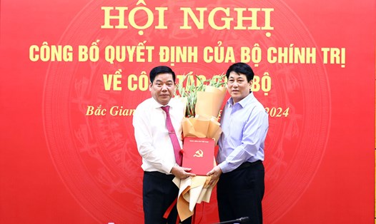 Thường trực Ban Bí thư Lương Cường (bên phải ảnh) trao quyết định và tặng hoa chúc mừng Trung tướng Nguyễn Văn Gấu. Ảnh: Quốc Trường