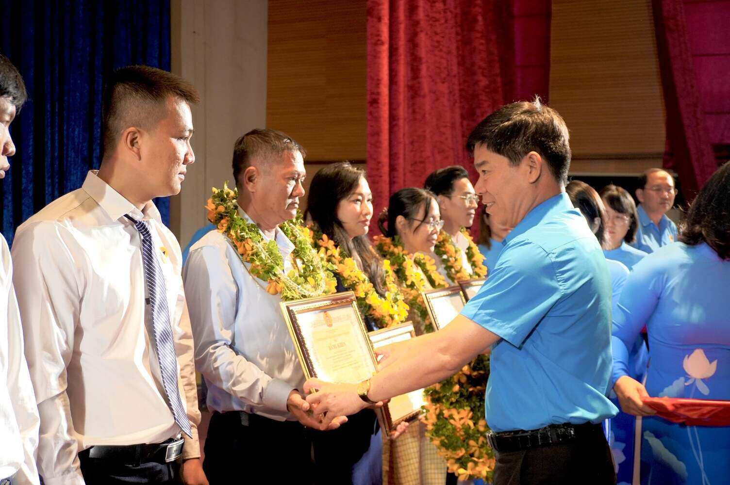 Ông Phạm Chí Tâm (bìa phải) - Phó Chủ tịch LĐLĐ TPHCM tặng hoa, Bằng khen của LĐLĐ Thành phố cho các gương lao động giỏi - lao động sáng tạo. Ảnh: Ngọc Ánh.