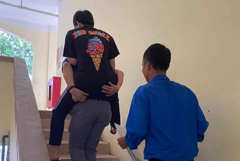 Tại điểm trường THPT Tân Dân, Phú Xuyên, một thí sinh bị gãy chân được tình nguyện viên cõng lên phòng thi.