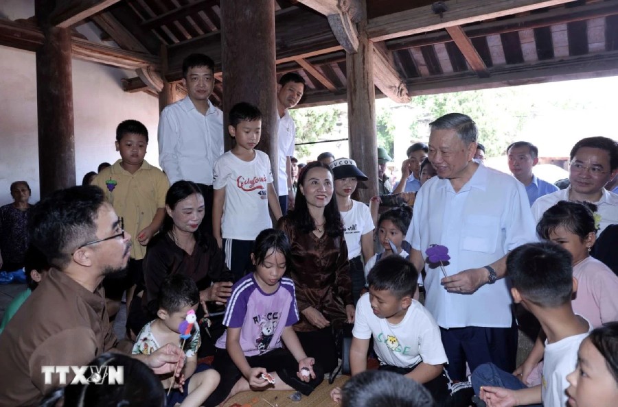 Chủ tịch nước Tô Lâm thăm các cháu thiếu nhi trải nghiệm làm tò he truyền thống tại đình Mông Phụ, làng cổ Đường Lâm. Ảnh: Nhan Sáng/TTXVN.