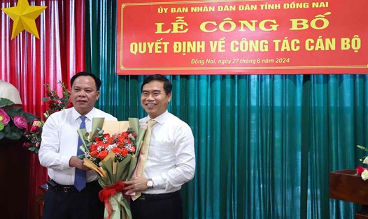 Quyền Chủ tịch UBND tỉnh Đồng Nai Võ Tấn Đức (bên trái ảnh) tặng hoa chúc mừng Quyền Chủ tịch UBND huyện Nhơn Trạch Nguyễn Thế Phong. Ảnh: HAC