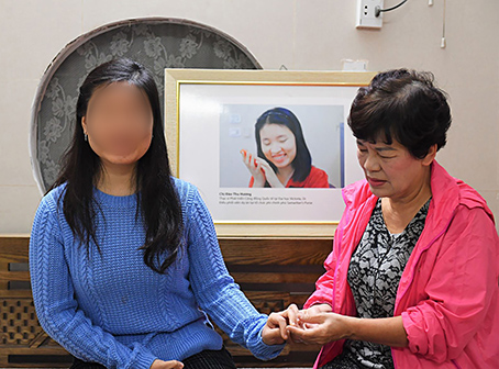 Bà Nguyễn Thị Hạnh xem móng tay con gái đã dài chưa để cắt cho gọn. Con gái là Đào Thu Hương là cô gái khiếm thị Việt Nam đầu tiên làm việc cho UNDP- chương trình phát triển Liên Hợp Quốc tại Việt Nam.