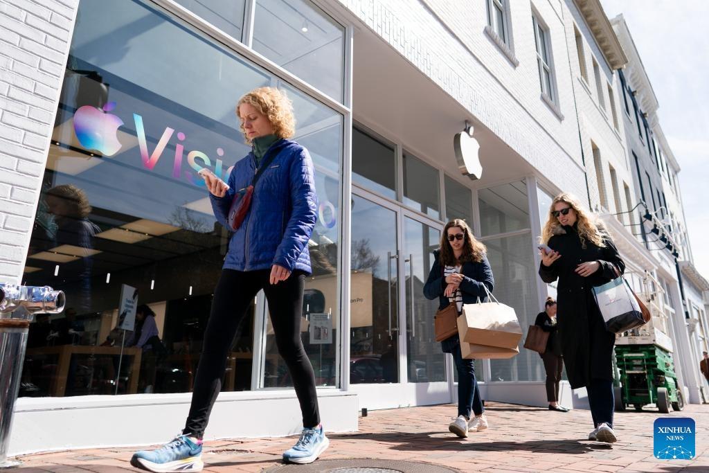 Du khách đi bộ trước một cửa hàng của Apple tại Thủ đô Washington D.C, Mỹ. Ảnh: Xinhua