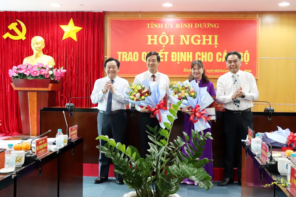Lãnh đạo tỉnh trao quyết định và tặng hoa cho ông Nguyễn Hồng Chương - Giám đốc Sở Y tế và bà Nguyễn Thị Thu Vân. Ảnh: UBND BD