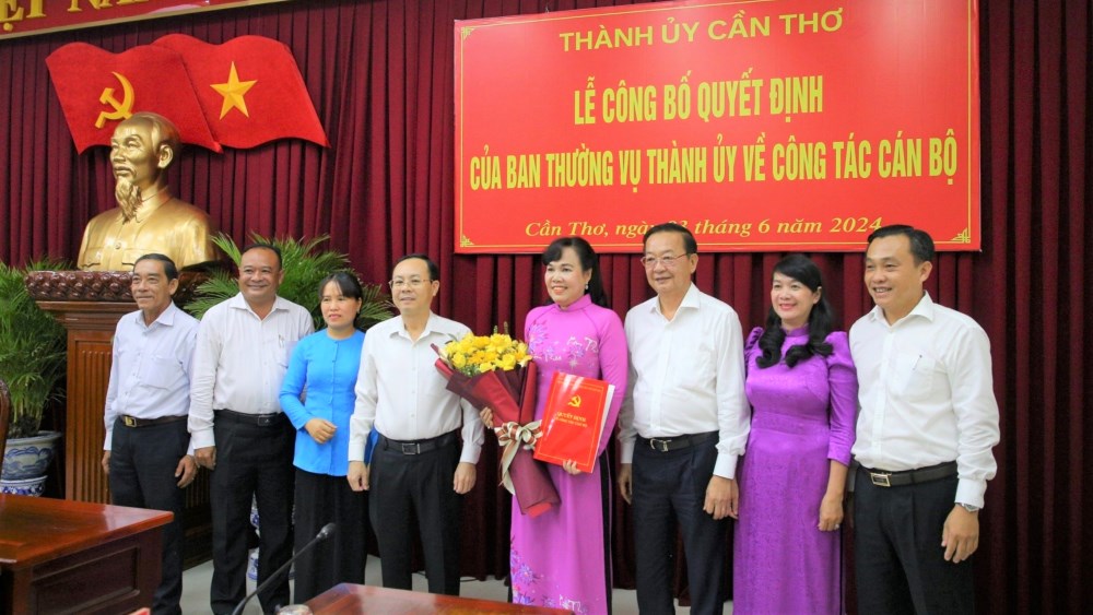 Bí thư Thành ủy Cần Thơ (áo trắng bên trái) trao quyết định và tặng hoa chúc mừng bà Võ Kim Thoa. Ảnh: Huy Linh. 