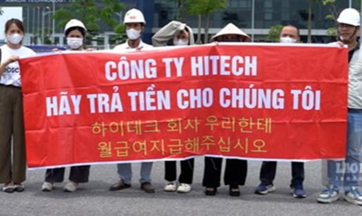 Một số chủ doanh nghiệp, người lao động căng băng rôn yêu cầu Công ty Hitech Vina thanh toán công nợ. Ảnh: Đền Phú