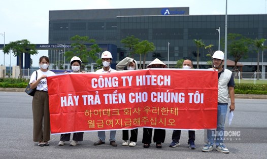 Một số chủ doanh nghiệp, người lao động căng băng rôn yêu cầu Công ty Hitech Vina thanh toán công nợ. Ảnh: Đền Phú
