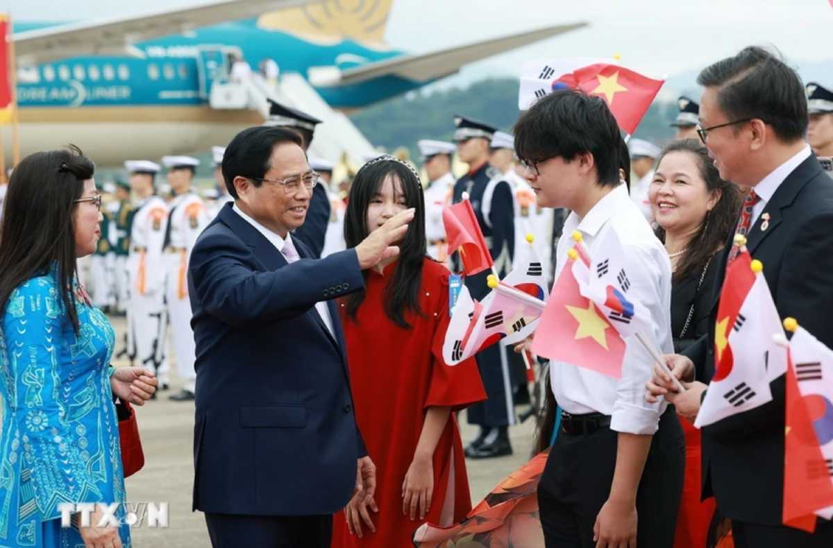 Cán bộ, nhân viên Đại sứ quán và cộng đồng người Việt Nam tại Hàn Quốc nồng nhiệt chào đón Thủ tướng và Phu nhân, cùng đoàn đại biểu Việt Nam. Ảnh: TTXVN