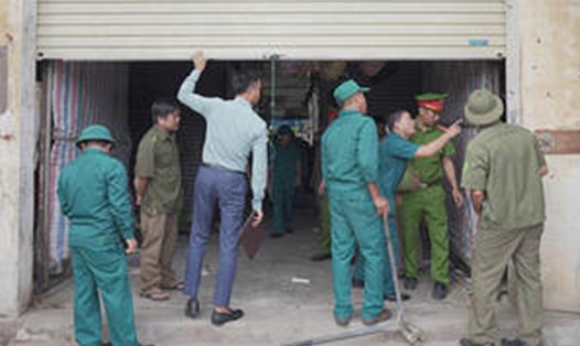 Lực lượng chức năng thị trấn Tiên Điền tiến hành đóng cửa chợ Giang Đình. Ảnh: Xuân Tuấn.