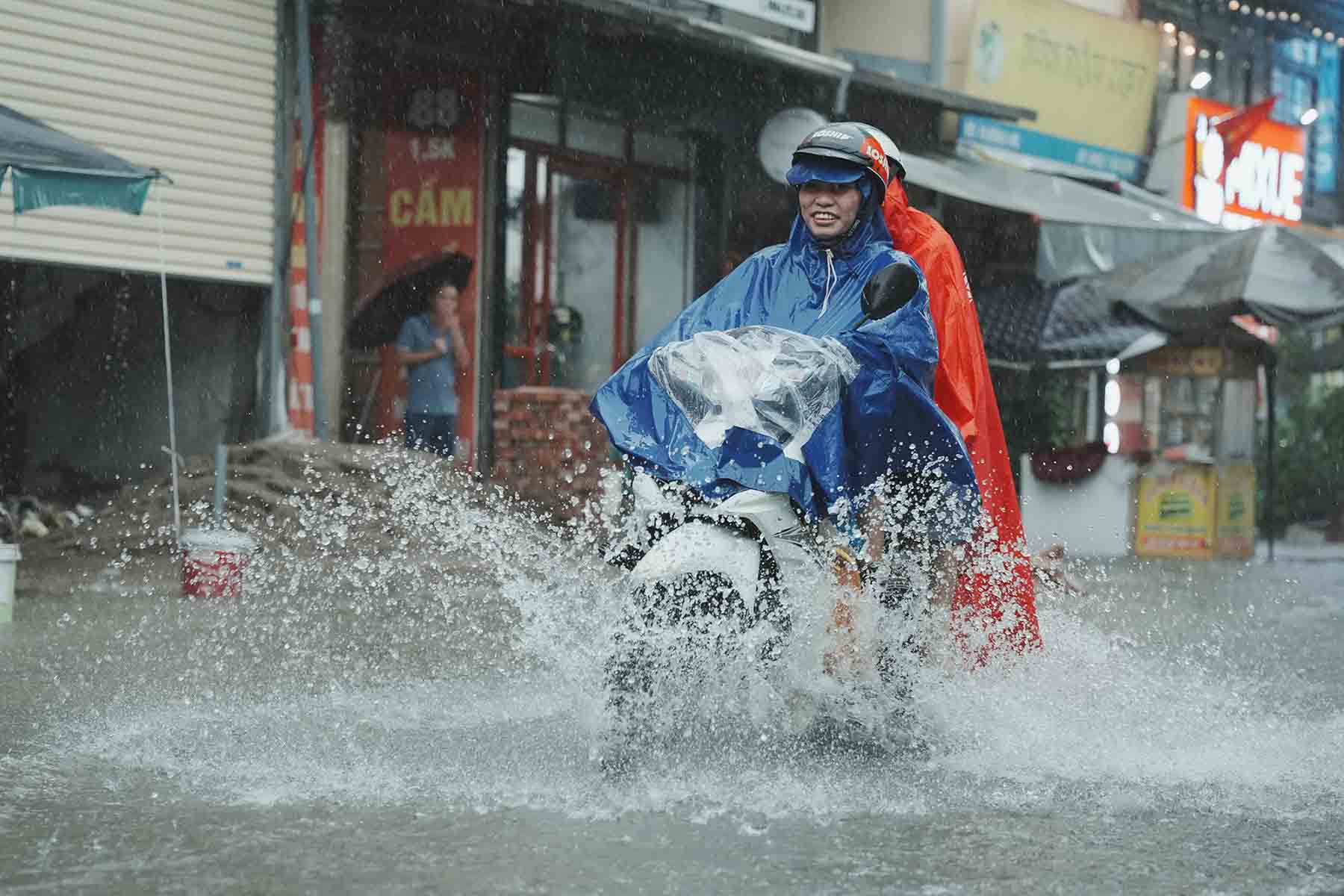 Người dân cần chú ý quan sát khi di chuyển dưới trời mưa, ngập úng. Ảnh: Hữu Chánh