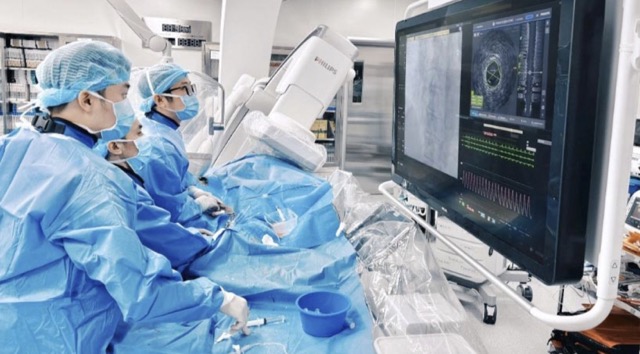 Bác sĩ can thiệp mạch đang đặt stent tái thông mạch vành cho người bệnh nhồi máu cơ tim. Ảnh: PHONG LAN