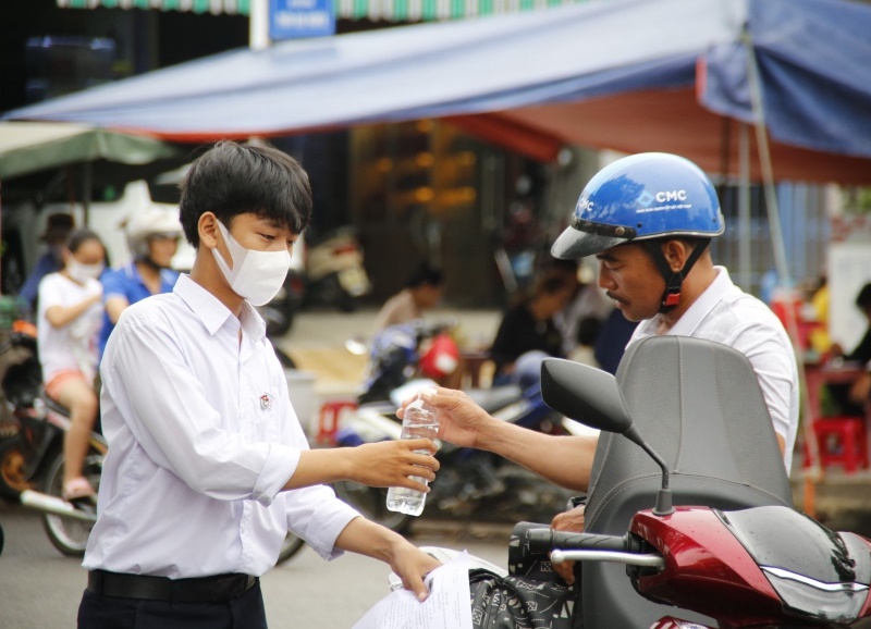 Gương mặt một phụ huynh lộ vẻ lo lắng khi tiếp nước, động viên con bước vào phòng thi. Ảnh Nguyễn Hoàng