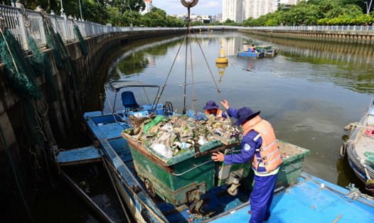 Công nhân Công ty TNHH MTV Môi trường đô thị TPHCM vớt rác trên kênh Nhiêu Lộc - Thị Nghè.  Ảnh: Minh Quân