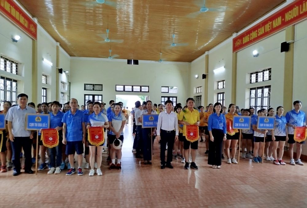 Đại diện lãnh đạo LĐLĐ tỉnh Thanh Hóa và huyện Hà Trung trao cờ lưu niệm cho các đội thi. Ảnh: Kim Huế