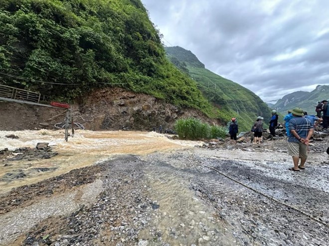 Mưa lớn gây sạt lở ở Hà Giang, máy xúc chặn dòng cho người dân vượt lũ