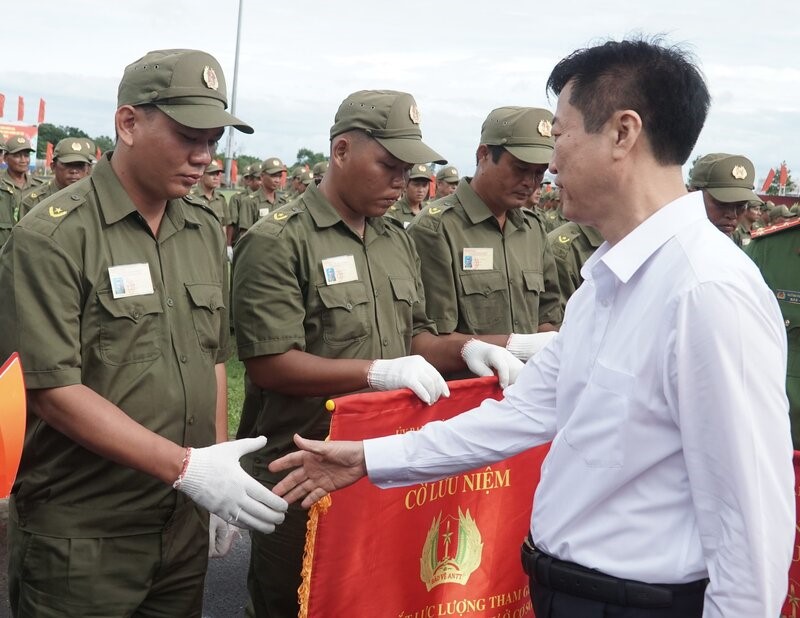 Ông Bùi Tuấn Quang, Phó trưởng Ban Dân vận Trung ương tặng cờ cho lượng tham gia bảo vệ an ninh, trật tự ở cơ sở tại tỉnh Cà Mau. Ảnh: Nhật Hồ