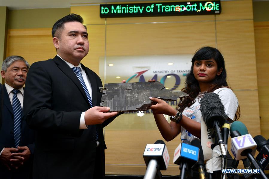 Mảnh vỡ nghi của MH370 được bàn giao cho Bộ trưởng Giao thông Vận tải Malaysia Anthony Loke Siew Fook (trái), ngày 30.11.2018. Ảnh: Xinhua